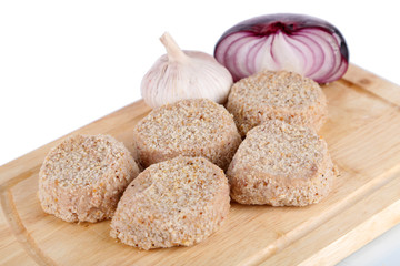 Meat patties on board isolated on white
