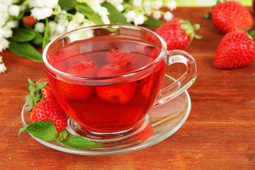 Delicious strawberry tea on table close-up