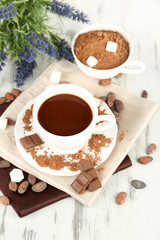 Cocoa powder in cup on napkin on wooden table
