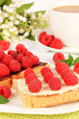 Delicious toast with raspberries on table close-up
