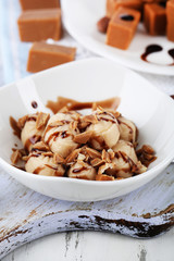 Many toffee on plate and in bowl on napkin on board close-up