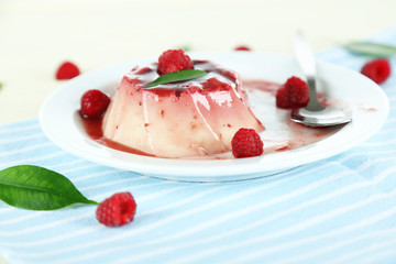 Panna Cotta with raspberry sauce, on wooden background