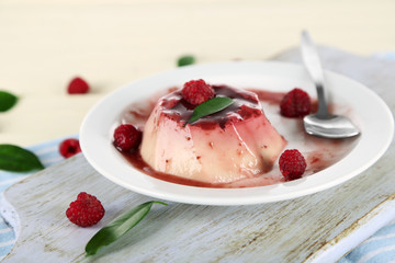 Panna Cotta with raspberry sauce, on wooden background