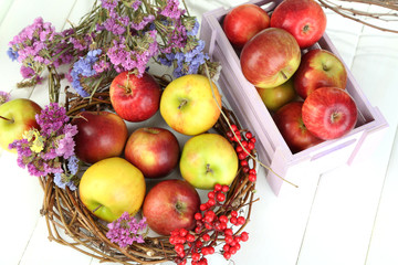 Juicy apples in box on white wooden table