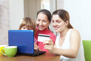Fototapeta na wymiar Happy family paying by credit card in internet