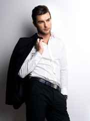 Fashion young man in white shirt holds the black jacket