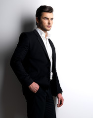 Fashion young man in white shirt holds the black jacket