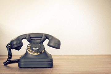 Old rotary telephone on table vintage photo