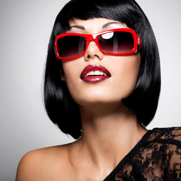 beautiful brunette woman with shot hairstyle with red sunglasses