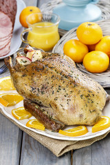 Roasted duck with oranges on wooden table