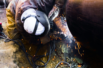 Close up shot welder until welding, sparks flying around.