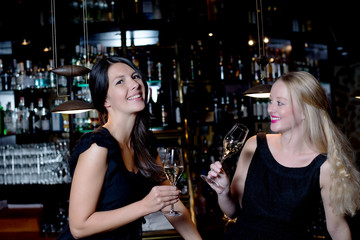 Two beautiful women celebrating with champagne
