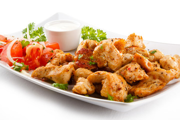 Grilled meat and vegetables on white background
