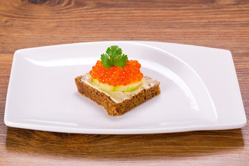 Sandwich with red caviar on the plate