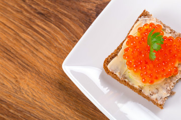 Sandwich with red caviar on the plate