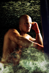 Fototapeta premium boxer man during boxing hiting heavy bag at training fitness