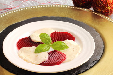 Beetroot and mozzarella salad with basil on a Christmas table