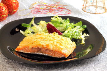Baked salmon with almond and cheese crust on a Christmas table