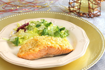 Baked salmon with almond and cheese crust on a Christmas table