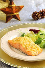 Baked salmon with almond and cheese crust on a Christmas table