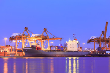 Container cargo freight ship at port twilight