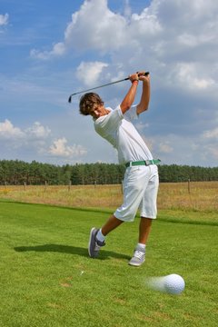 Golf, golfer striking the ball