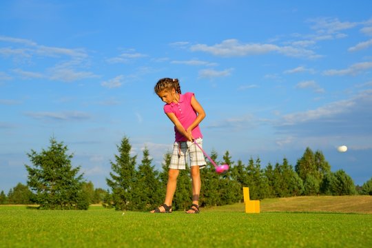 Golf, girl golfer hitting the ball