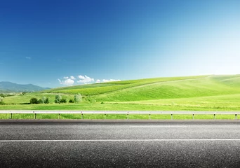 Rolgordijnen asfaltweg en perfect groen veld © Iakov Kalinin
