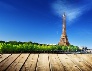 background with wooden deck table and Eiffel tower in Paris