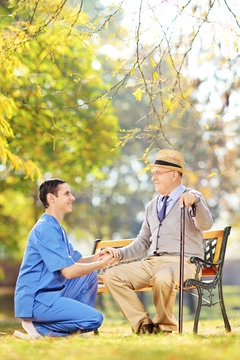 Male healthcare professional helping senior man