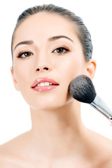 Pretty woman with a cosmetic brush, white background