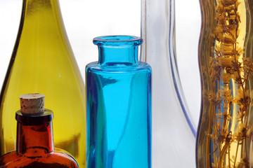 Colorful glass vases in the window with the plant