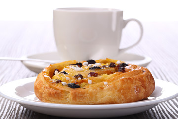 Tea and sweet bun with raisins