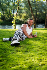 Man Lying On Grass And Holding Bottle Of Water