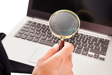 Man Holding Laptop And Magnifying Glass