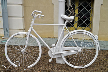 bicicletta colorata di bianco legata ad un lampione