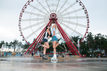 Two young sensual women skating in park