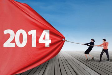 Business team pulling new year 2014 outdoor