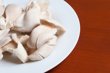 raw mushrooms in a plate on wooden table