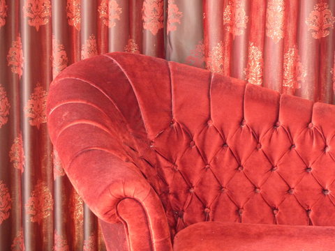 Kitschiges rotes Sofa mit Samt und Pl&uuml;sch vor rotem Vorhang in einem billigen heruntergekommenen Hotel in Bodrum am &Auml;g&auml;ischen Meer in der Provinz Mugla in der T&uuml;rkei