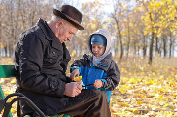 Elderly man with his grandson in the park