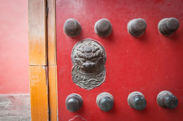 Lion head on red doors in Forbidden City, Beijing, China