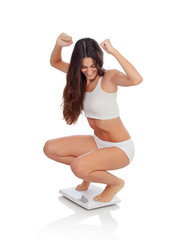 Happy woman celebrating her new weight on a scale