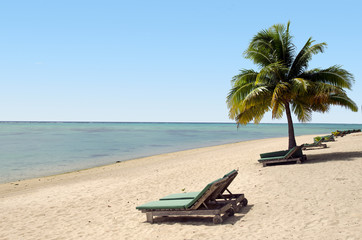 Fototapeta na wymiar Empty beach chairs on empty tropical beach
