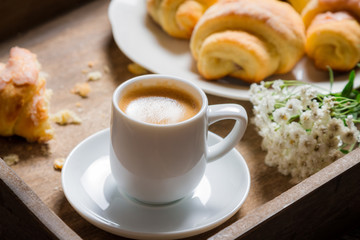 Breakfast in bed with espresso, flower and croissant