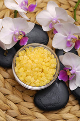 Obraz na płótnie Canvas spa salt in bowl and white orchid with stones on wicker mat