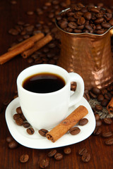 Coffe cup and metal turk on wooden table