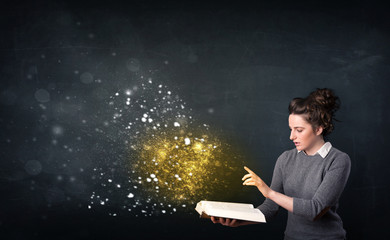 Young lady reading a magical book