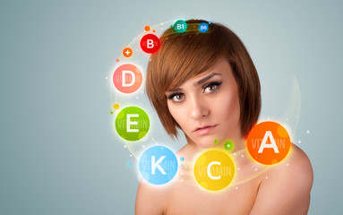 Pretty young girl with colorful vitamin icons and symbols