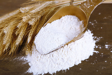 The wholemeal flour in scoop on wooden table